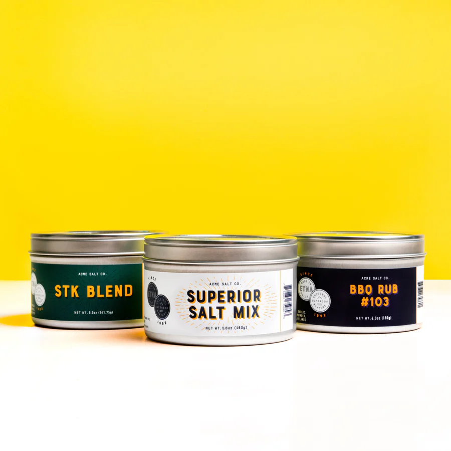 Eight shirts arranged on table in black, olive, grey, blue, white, red, mustard, and green.